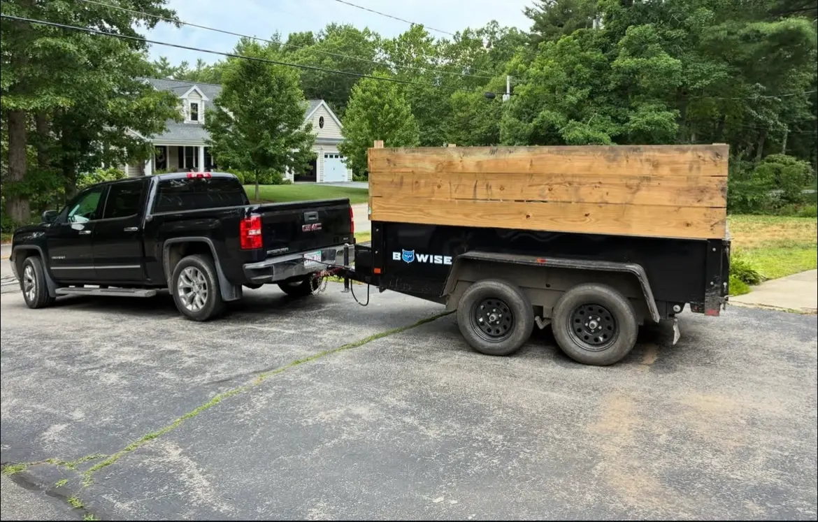 D&B Landscaping truck and dump trailer parked on an Easton street